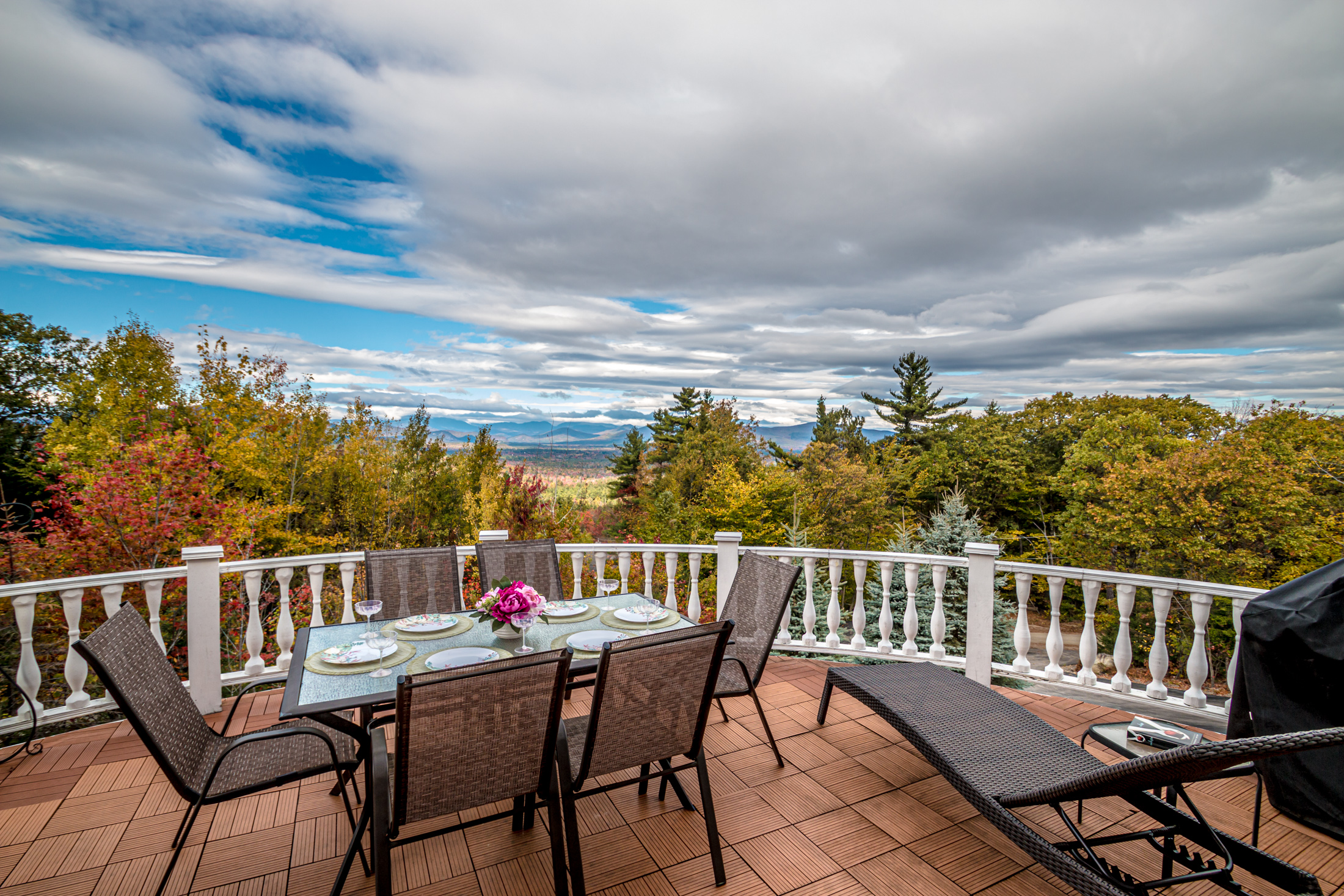 Deck with a private hot tub overlooking an autumn mountain valley