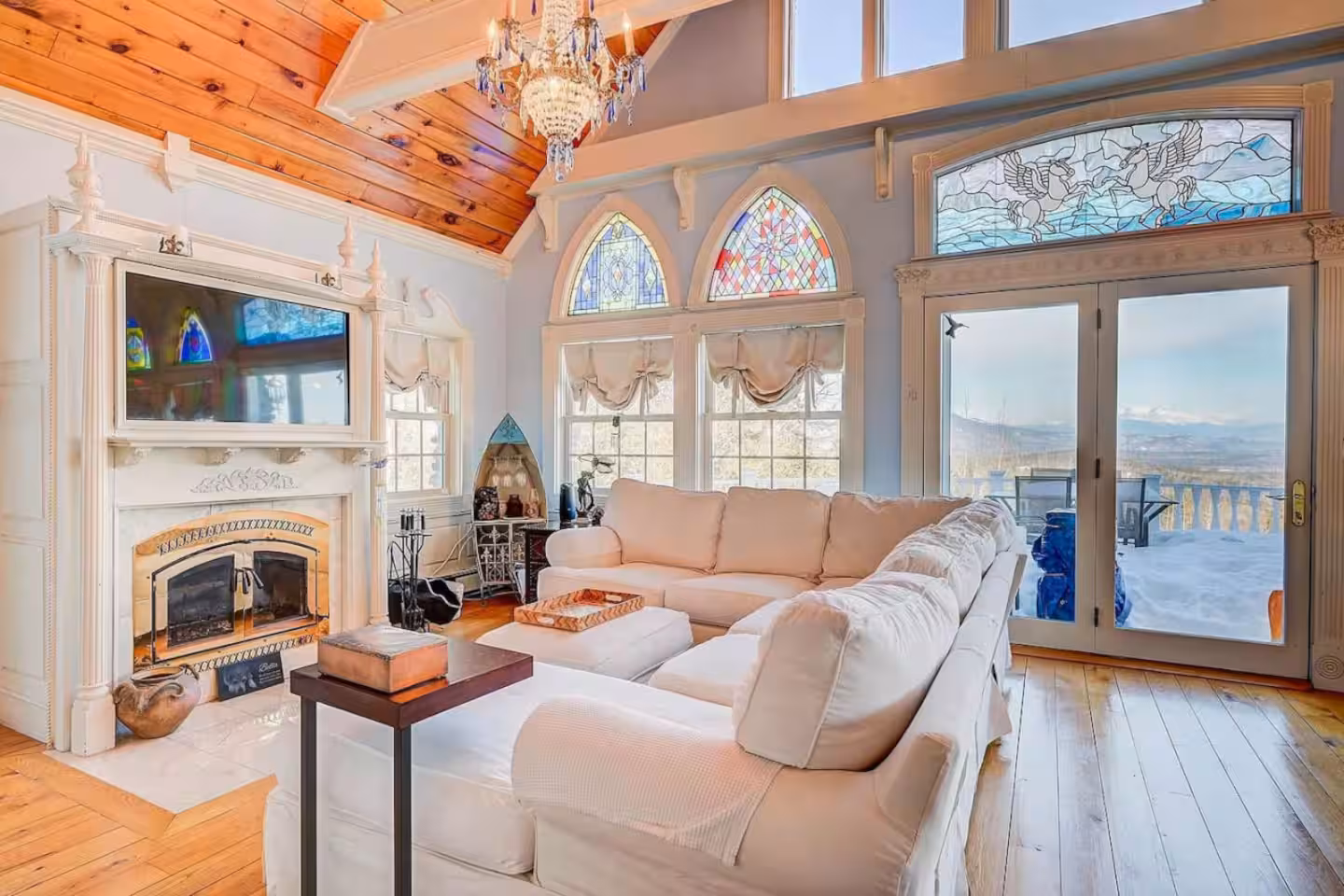 Chalet living room with a floor-to-ceiling stone fireplace and timber beams